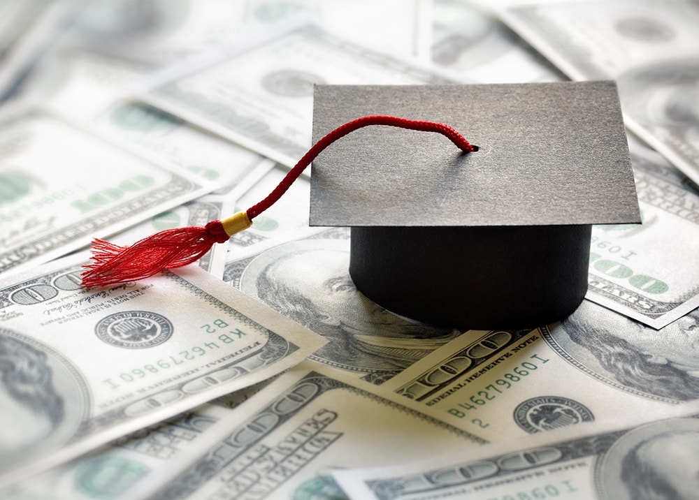 graduation cap on money