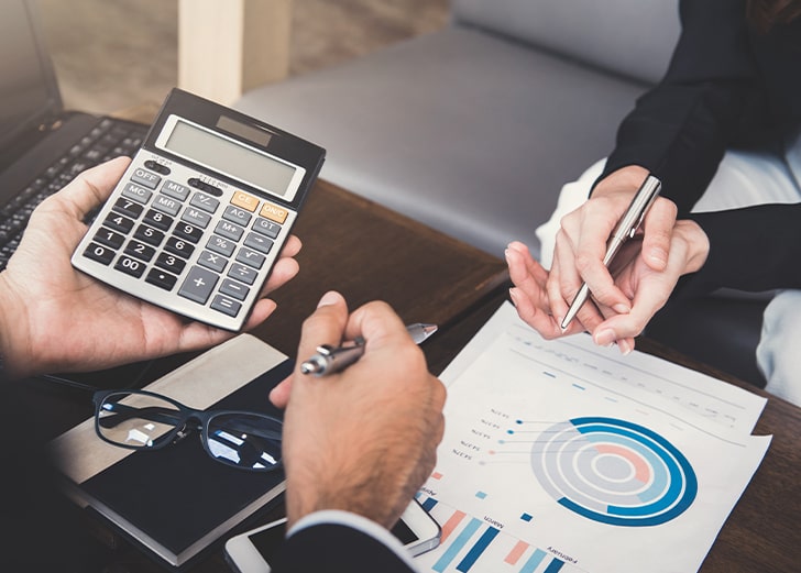 close up of financial advisor's hands as he works with a client to assess her financial mindset