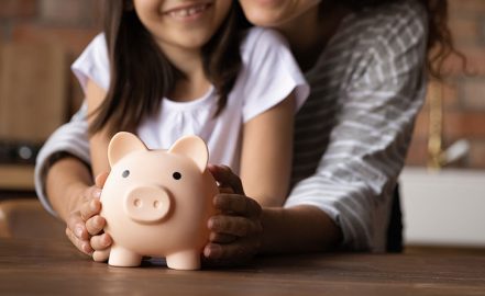 mom and daughter putting money in savings for college funds