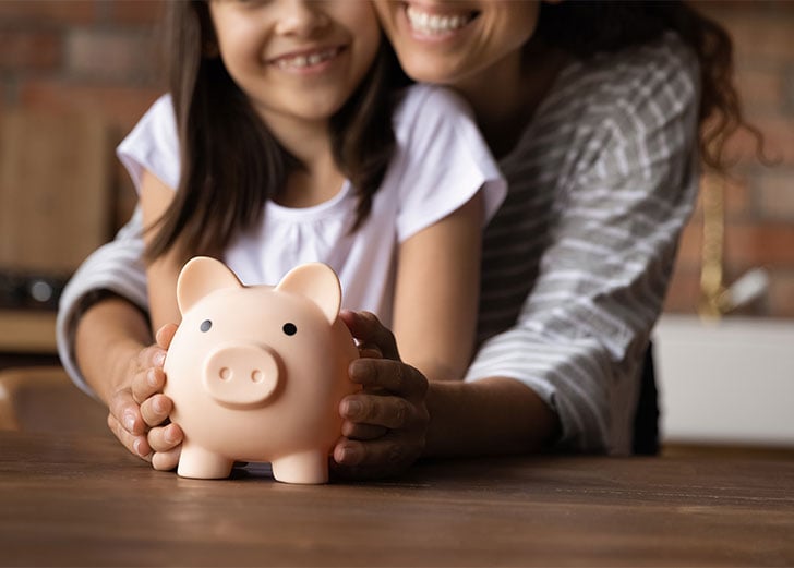 mom and daughter putting money in savings for college funds