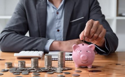a man putting money in a piggy bank