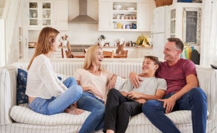 Family with teenage children relaxing on a sofa together