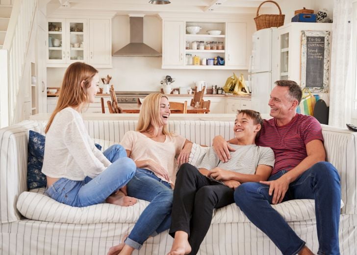 Family with teenage children relaxing on a sofa together